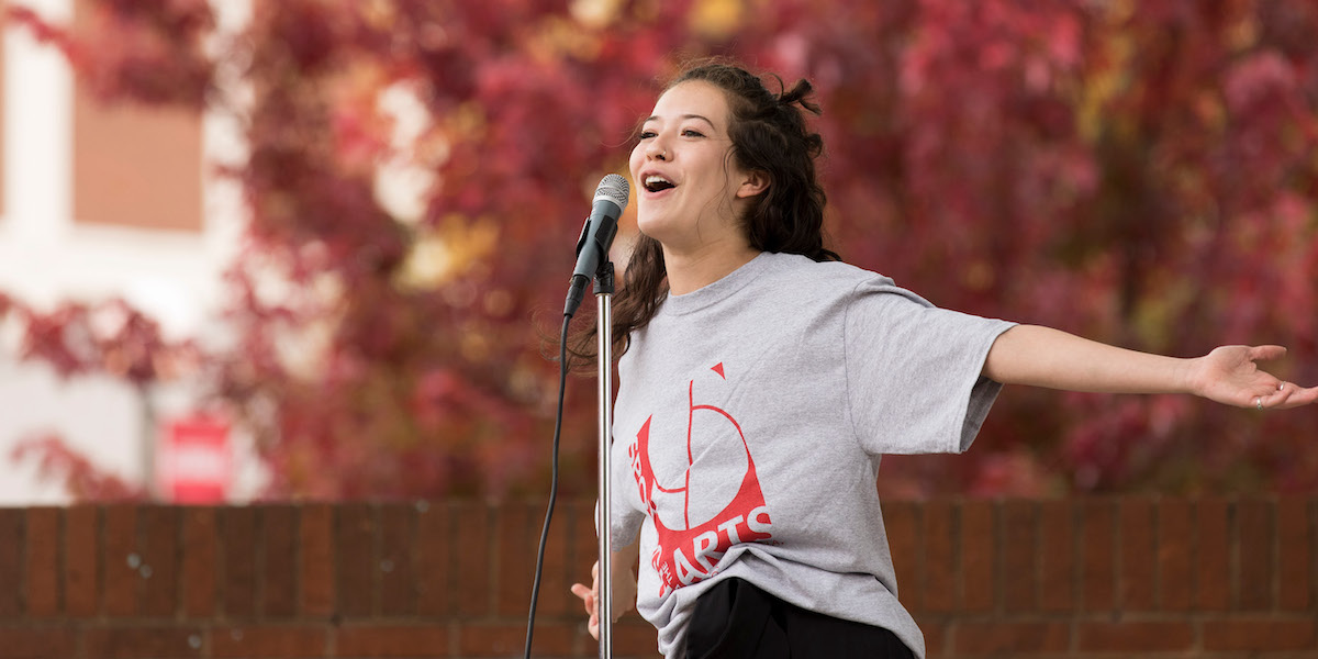 A student sings at Tate Plaza during UGA's Spotlight on the Arts festival.